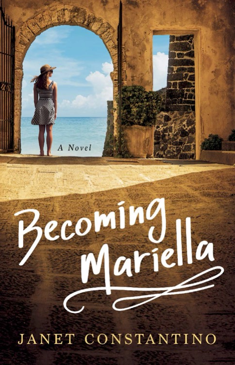 A woman in a striped dress and sunhat stands by an open stone gate, gazing at the ocean. The title Becoming Mariella by Janet Constantino is displayed in large text on the sunlit ground.