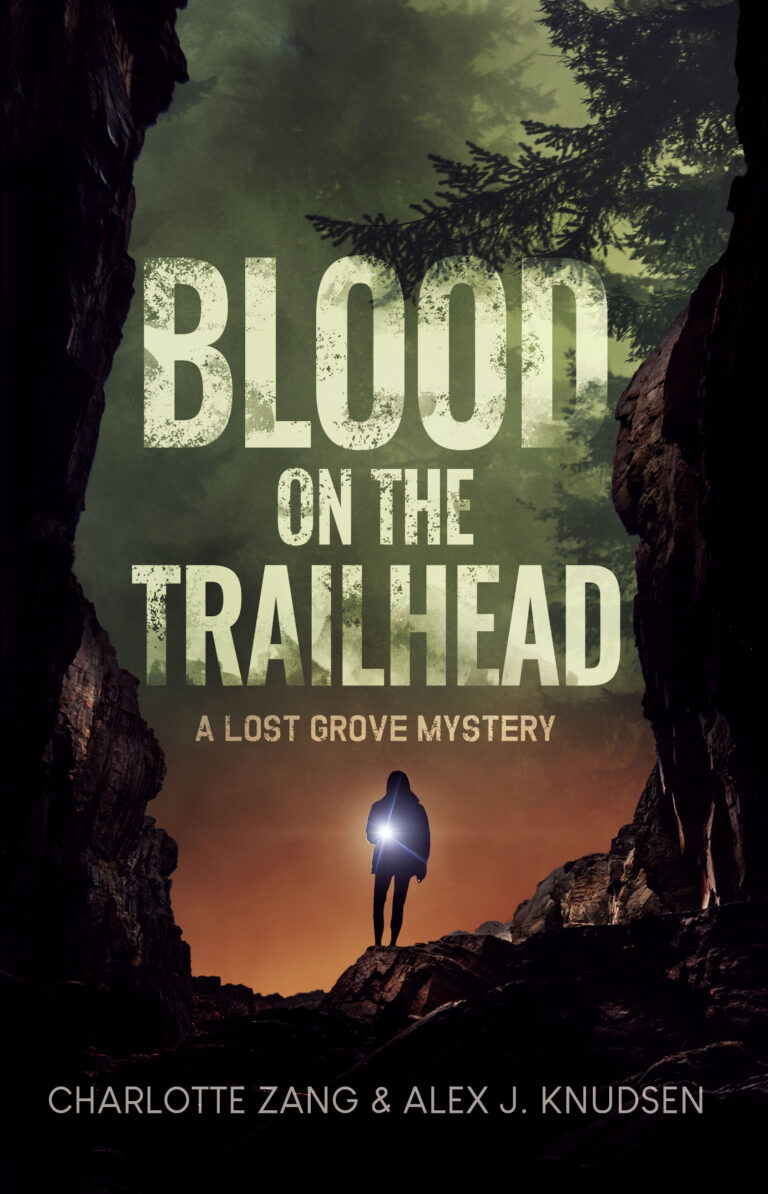 A person holding a flashlight stands at the entrance of a rocky cave at sunset, hinting at mystery. The book title Blood on the Trailhead: A Lost Grove Mystery appears above, with authors Charlotte Zang & Alex J. Knudsen below.