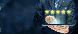 A person in a suit uses a tablet with glowing stars, symbolizing review visibility and next steps.